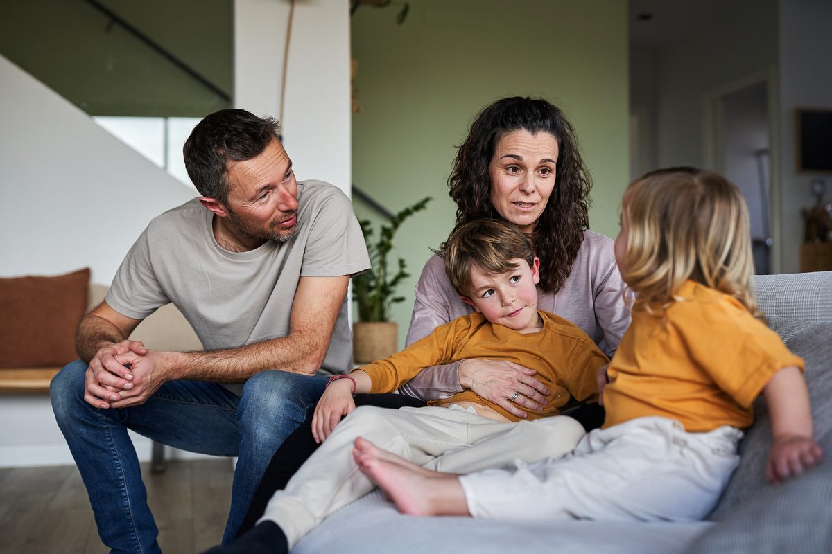 Parents sitting and talking with their two young children at home